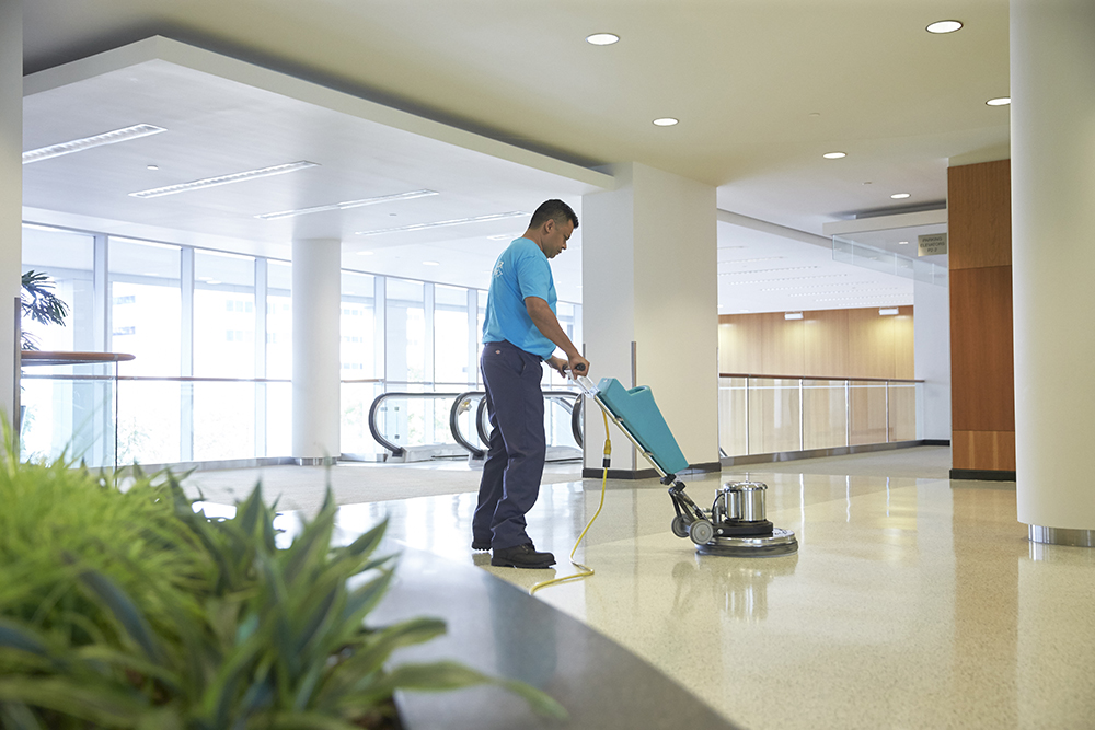 Male cleaning staff polishing lobby floor